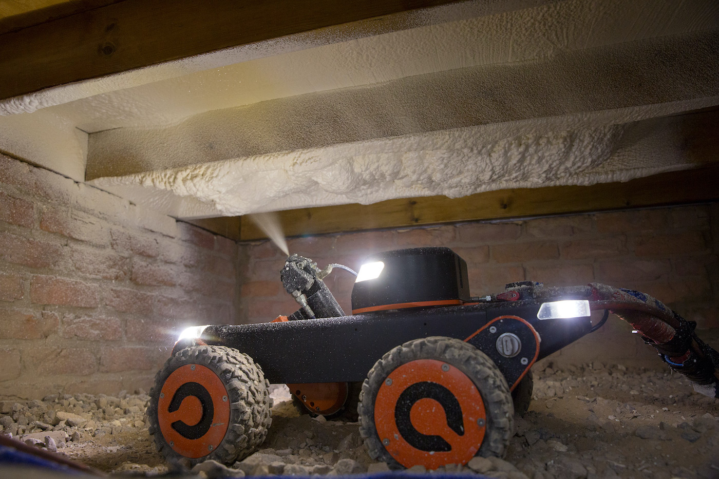 Q-Bot's robot spraying insulation underneath the floor